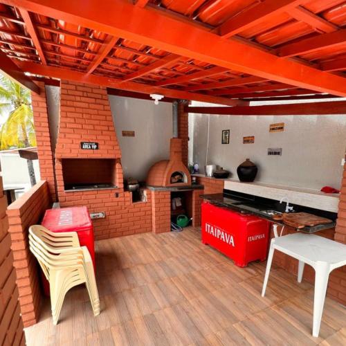 a kitchen with a brick oven and a table and chairs at Casa De Praia Com Seis Súites Climatizadas in Lauro de Freitas