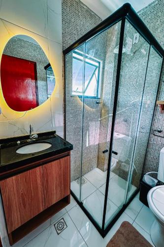 a bathroom with a glass shower and a sink at Casa Amar Cumbuco in Cumbuco