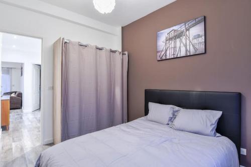 une chambre avec un lit et un tableau au mur dans l'établissement 4P haut de gamme Nice Ouest Promenade des anglais, à Nice