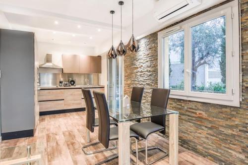 une salle à manger avec une table et des chaises en verre dans l'établissement 4P haut de gamme Nice Ouest Promenade des anglais, à Nice