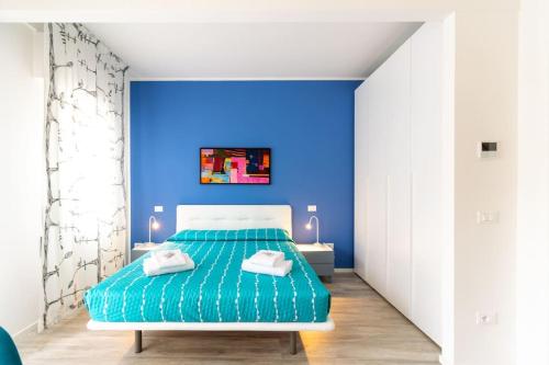 a blue bedroom with a bed and a blue wall at Modern Studio della Valle x2 in Padova