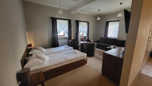 Hotel Chańcza في Raków: غرفة نوم مع سرير وغرفة معيشة
