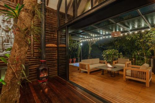 un porche cubierto con mesa y sillas en Espectacular Chalet a tan solo 20 minutos de Medellín, en Medellín