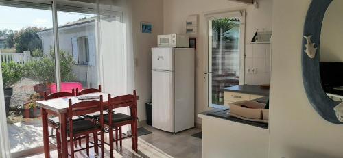 une petite cuisine avec une table et un réfrigérateur dans l'établissement studio maisonnette, à Vaux-sur-Mer