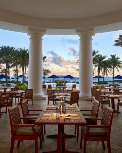 a restaurant with tables and chairs and palm trees at Marriott St Marteen 3 bedroom Villa in Dawn Beach