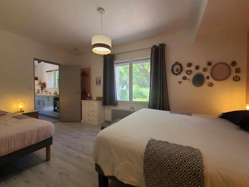 a bedroom with a large white bed and a kitchen at La Dame de cœur 05 in Antonaves