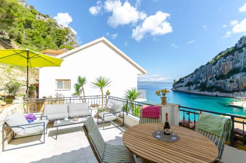 a patio with a table and chairs and the ocean at Apartments Apollo in Zastražišće