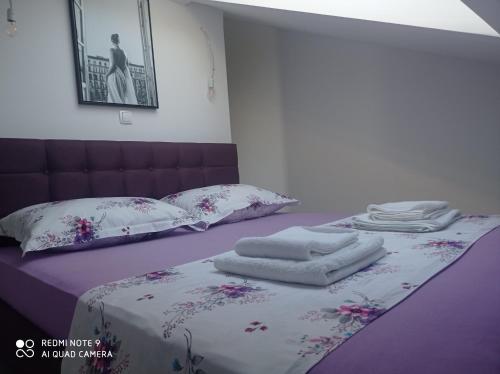 a bedroom with a bed with towels on it at Studioapartman Pink Živogošće in Živogošće