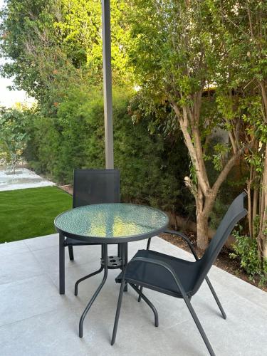 uma mesa de vidro e uma cadeira num pátio em Royal Sunset Studios & Apartments em Limassol