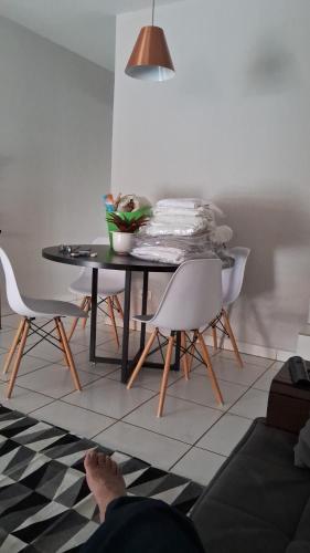 eine Person mit den Füßen auf einem Tisch und Stühlen in der Unterkunft Casa 14 in Presidente Prudente