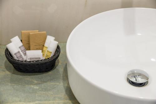 a basket of toiletries sitting next to a bathroom sink at Donna Adriana Rooms in Agropoli