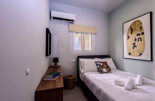 um quarto com uma cama e uma mesa em Open Beyond em Heraklion
