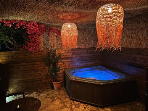 a hot tub in a room with two hanging lights at 4 MOUNTAIN HILLS in Megalo Chorio