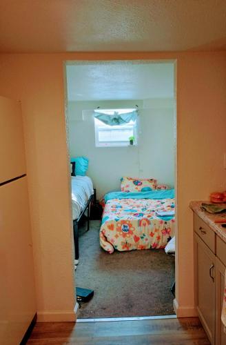 a small bedroom with two beds and a window at Big Horn Motel in Cheyenne