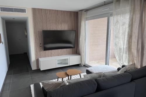 un salon avec un canapé et une télévision à écran plat dans l'établissement Apartment of standing with swimming pool, à Saint-Raphaël