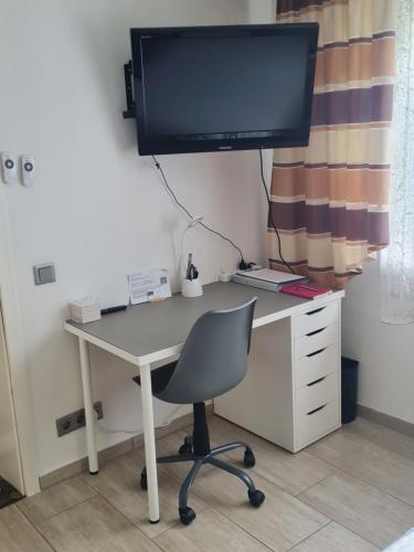 a computer desk with a monitor and a chair at Appartement Willmeroth in Königswinter