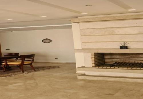 a room with a fireplace with a table and a dining room at Prestigia luxurious and cosy apartment 169 m2 in Rabat