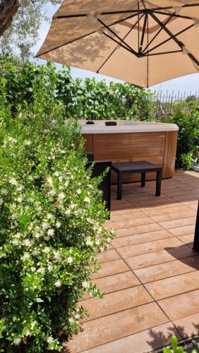 an umbrella and a bench with a bath tub at Casa della Zagara in Acireale