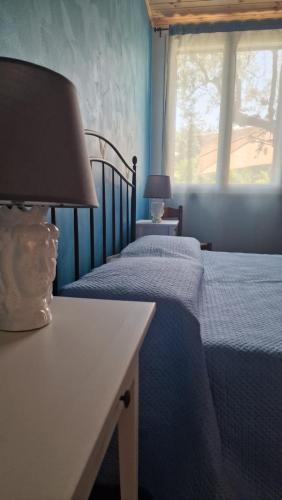 a bedroom with two beds and a table with a lamp at Casa della Zagara in Acireale