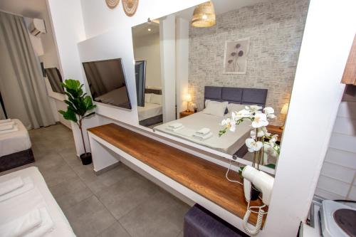a bedroom with a large bed and a large mirror at Sophia seaview suites & restaurant in Nea Vrasna