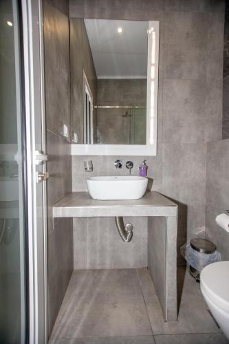 a bathroom with a sink and a mirror at Sophia seaview suites & restaurant in Nea Vrasna