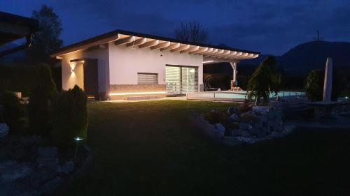 a small white house at night with a yard at Villa Vanessa - Ferienwohnungen - Appartement in Gösselsdorf