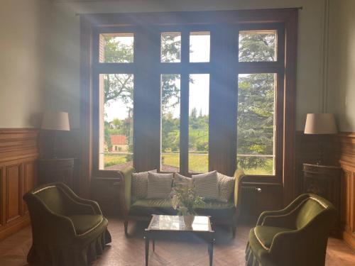 a living room with a couch and two chairs and a window at Castle Of Saint Germain Des Rives in Saint-Germain-des-Rives