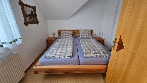 2 camas en una habitación pequeña con puerta en Villa Vanessa - Ferienwohnungen - Appartement, en Gösselsdorf