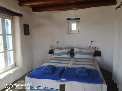a bedroom with a bed with blue pillows at Villa Antinaxos in Ambelas