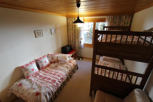 a bedroom with a bed and two bunk beds at Forêt C2 in Chateau-d'Oex