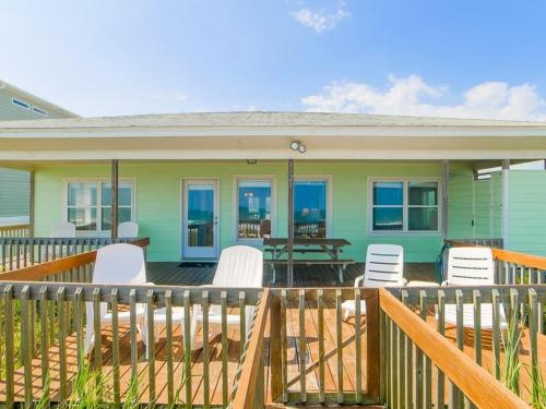 a house with a deck with chairs and a table at Costic in Topsail Beach