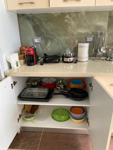 a kitchen shelf with pots and pans on it at Tinas Rooms in Durrës