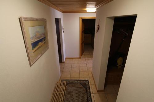 a hallway with a tile floor and a painting on a wall at Forêt C2 in Chateau-d'Oex