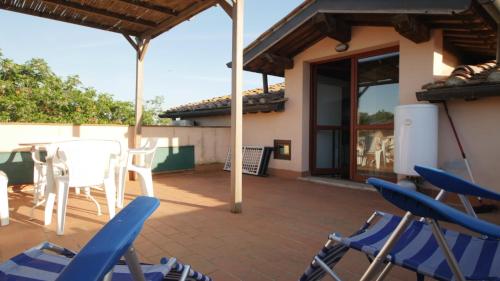 a patio with chairs and a table and a house at Capalbio - Retreat in Capalbio