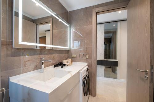 een badkamer met een witte wastafel en een spiegel bij Mayer Skycon Residence Besiktas in Istanbul
