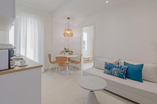 een witte woonkamer met een bank en een tafel bij E & G Figareto Apartments 6 in Kanoni