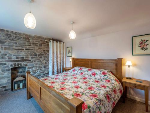 1 dormitorio con cama y pared de piedra en 1 Bed in Knighton 51897, en Beguildy