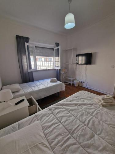 a bedroom with two beds and a window at Boa Noite Casa de Hospedes in Lisbon