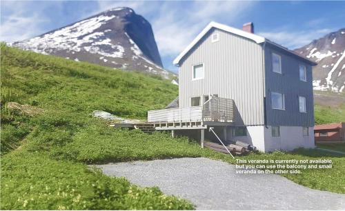 ein Haus auf einem Hügel neben einem Berg in der Unterkunft Vacation Home in Fjordgård with views of Segla and the Fjord in Fjordgård