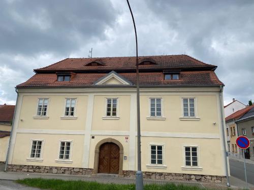 a large yellow building with a brown roof at Galerie Vila Lucia 5 -Loft apartmán in Plzeň