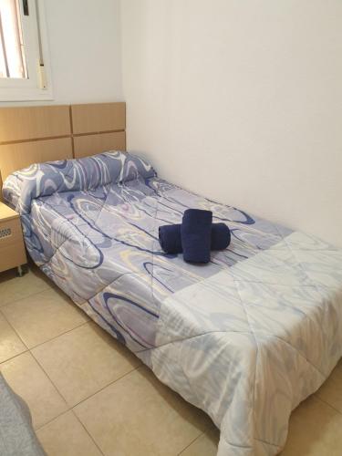 Una cama con una almohada azul encima. en Holiday TorremarMED020, en El Borseral