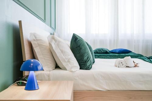 a bed with green and white pillows in a room at Maison Turin in Turin