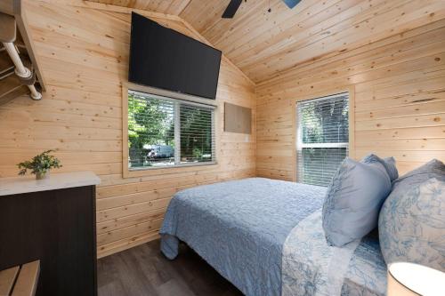a bedroom with a bed and a flat screen tv at Brand New Cabin in Kernville