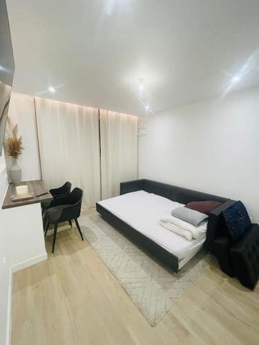 une chambre avec un lit, une chaise et un bureau dans l'établissement General Suite - Strasbourg Hyper Centre, à Strasbourg