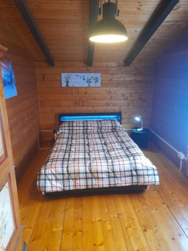 1 dormitorio con 1 cama en una habitación de madera en Chalet Aledia en Pessinetto