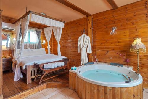 een badkamer met een bad en een bed in een kamer bij הפינה היפה של צביה in Had Nes