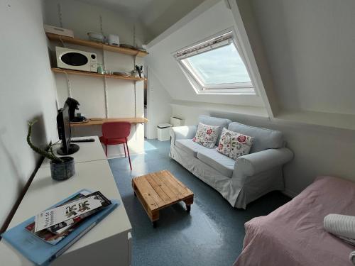 un petit salon avec un canapé et une table dans l'établissement Studio Cosy avec Parking Privé, à Caen