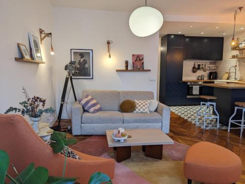 un salon avec un canapé et une table dans l'établissement Appartement élégant - Fbg Saint Denis, à Paris