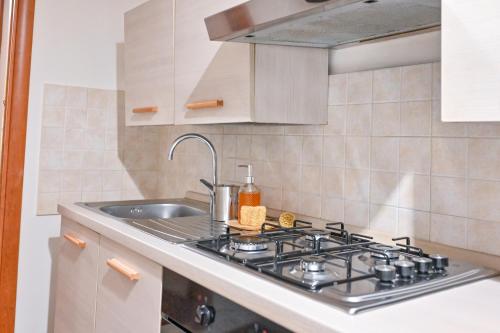 una cocina con estufa y fregadero en De Natura Partenope - Boutique Home, en Nápoles