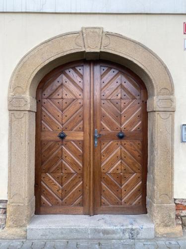 a wooden door on a building with an arch at Vila Lucia - Apartmán 4 in Plzeň